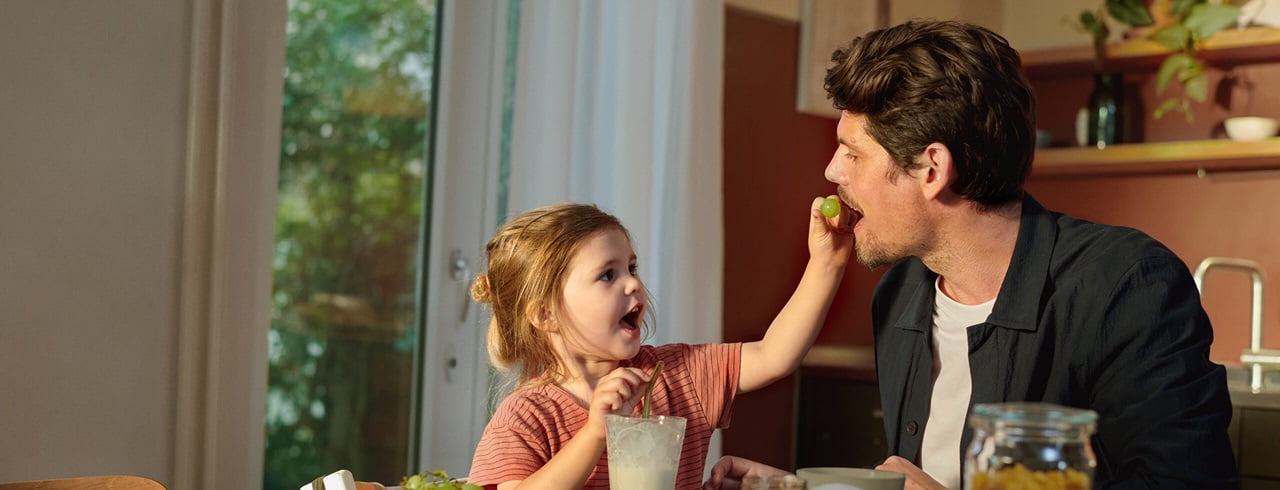 Vater mit Tochter in Küche am Essen